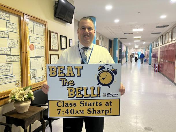 Wareham High School Principal Scott Palladino holds a sign reminding students to get to class before the morning bell. Photo by Grace Roche