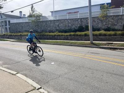 A cyclist rounds the bend on Sandwich Road. 