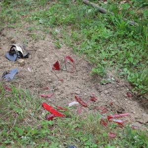 Scattered, shattered pieces of car lights sit in the lawn behind the 7-Eleven. 