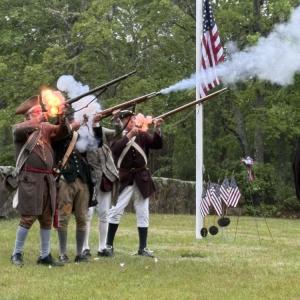 The Minutemen and Militia shoot guns dressed in period clothing.