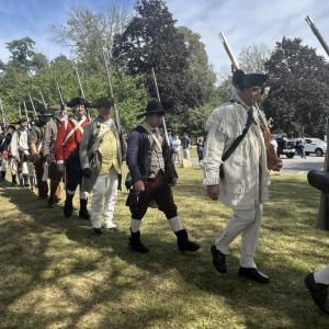 The Minutemen march in traditional clothing during the ceremony.
