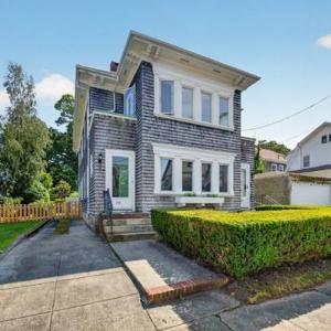 Front of 370 Maple Street, a cedar-shingled two-family home with trimmed hedges across from Buttonwood Park, New Bedford