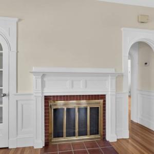 Brick fireplace with a white mantel and arched doorway in Unit 2 at 370 Maple Street, New Bedford, MA